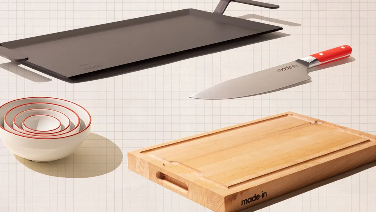 Assorted kitchenware including a chef's knife, a set of nesting mixing bowls, and two chopping boards displayed on a grid background.