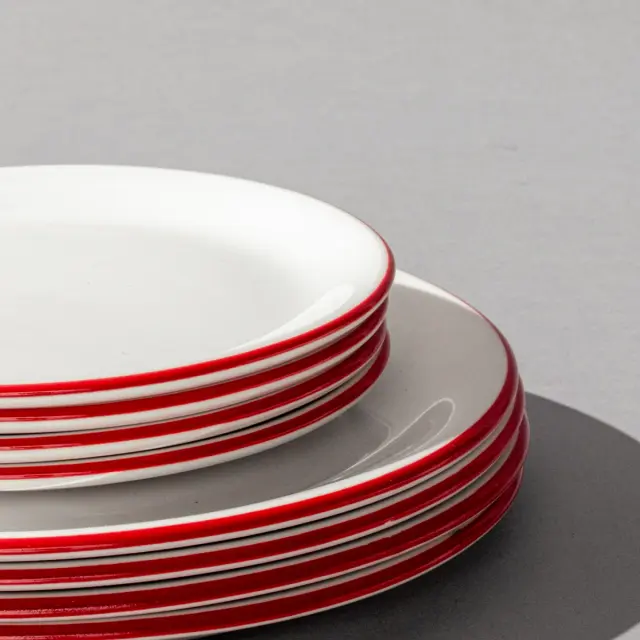 Red rim plateware on a grey background